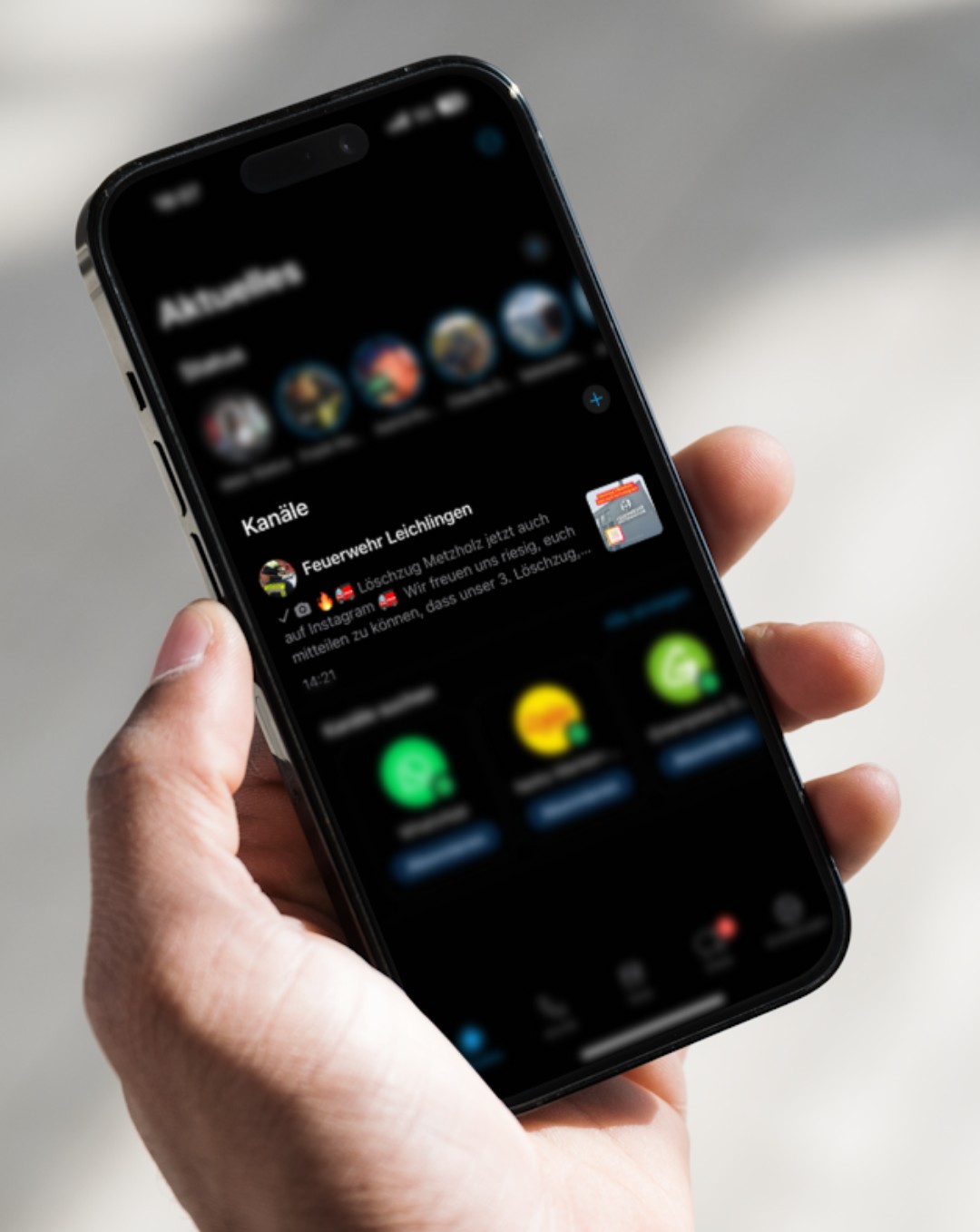 Hand mit Smartphone, auf dem der WhatsApp-Kanal der Feuerwehr Leichlingen zu sehen ist